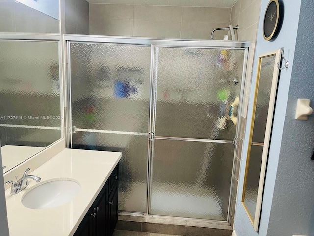 bathroom featuring a shower with shower door and vanity