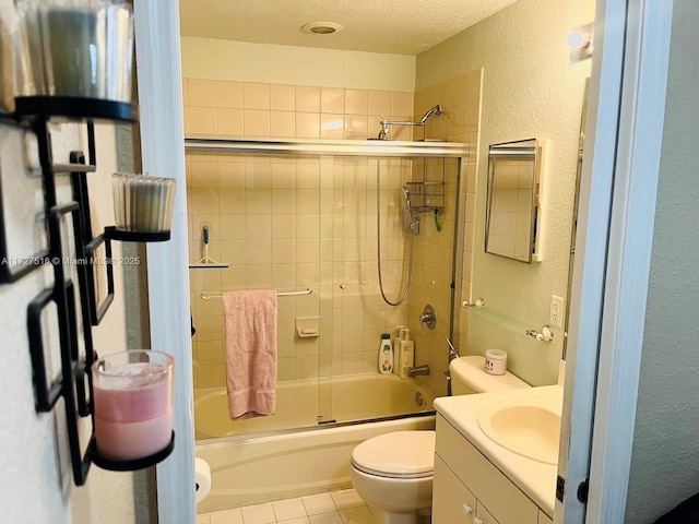 full bathroom with a textured ceiling, shower / bath combination with glass door, tile patterned floors, vanity, and toilet