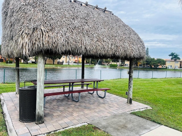 surrounding community with a gazebo, a water view, and a lawn