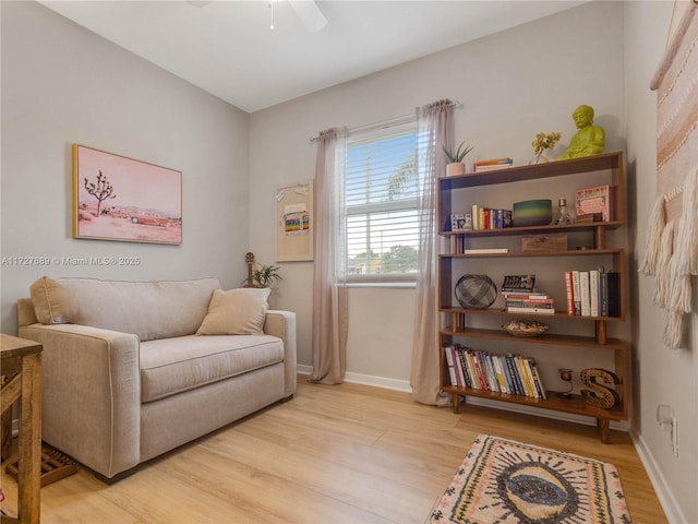 living area with ceiling fan and light hardwood / wood-style flooring