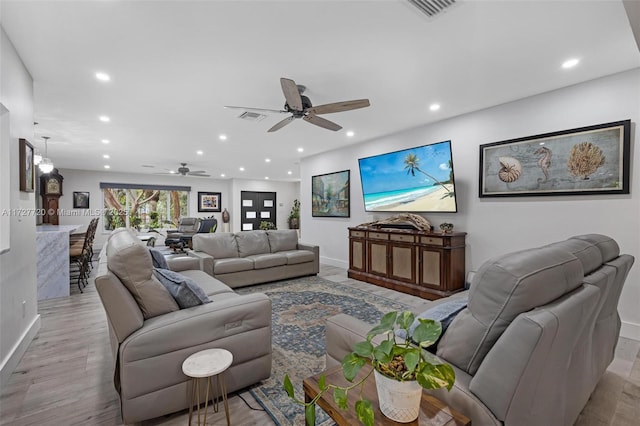 living room featuring ceiling fan and light wood-type flooring