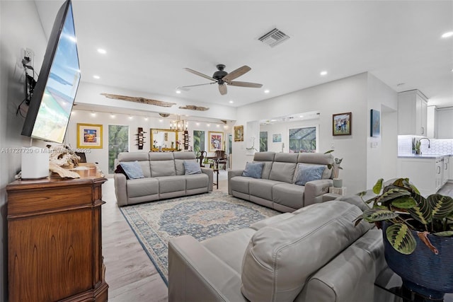 living room featuring sink, light hardwood / wood-style flooring, and ceiling fan