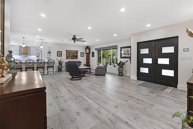 entrance foyer featuring french doors, ceiling fan, and light hardwood / wood-style flooring