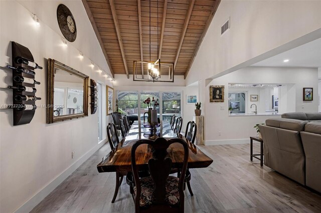 dining area with wood ceiling, high vaulted ceiling, and light hardwood / wood-style flooring