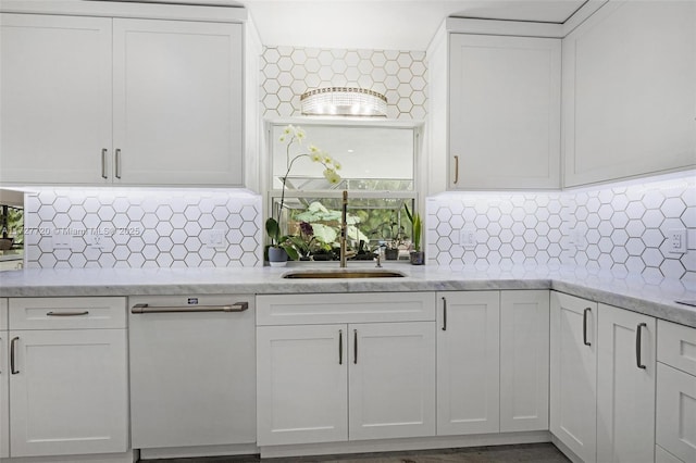 kitchen featuring light stone counters, sink, decorative backsplash, and white cabinets