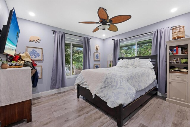 bedroom with multiple windows, ceiling fan, and light wood-type flooring