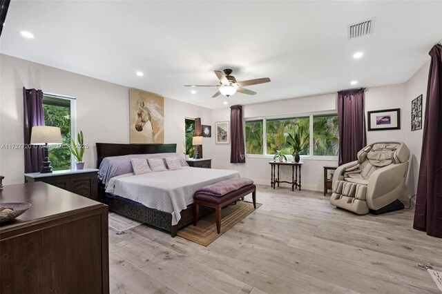 bedroom featuring multiple windows, ceiling fan, and light hardwood / wood-style flooring