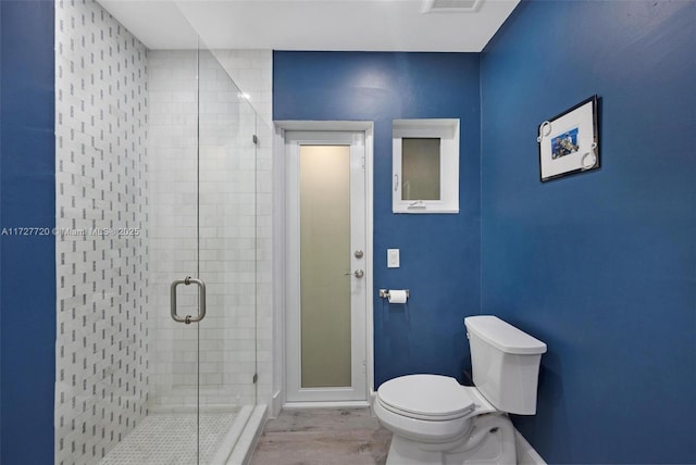 bathroom with wood-type flooring, toilet, and walk in shower