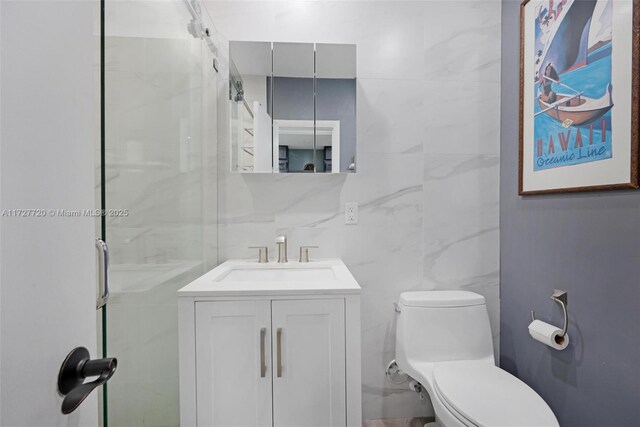 bathroom featuring vanity, toilet, an enclosed shower, and tile walls