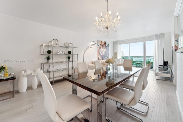 dining space with an inviting chandelier and light hardwood / wood-style flooring