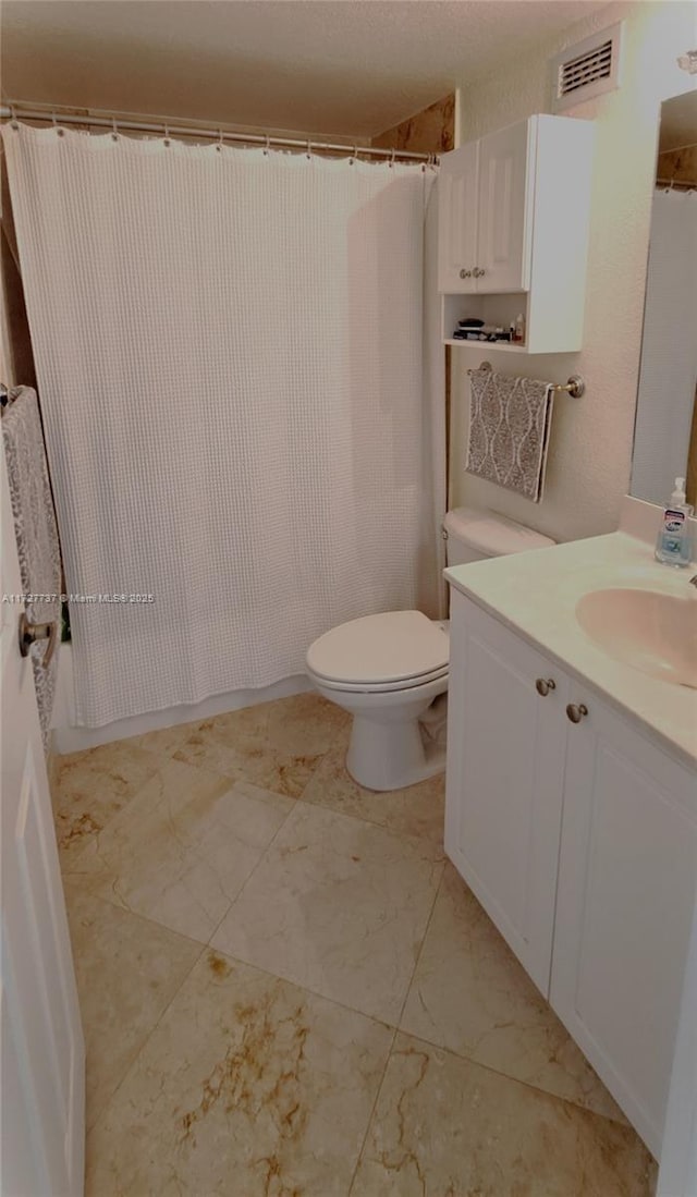 bathroom with curtained shower, toilet, and vanity