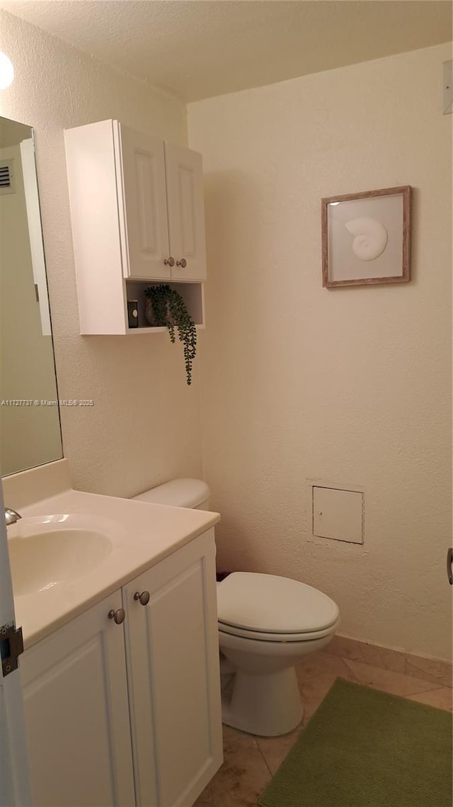 bathroom with tile patterned floors, vanity, and toilet