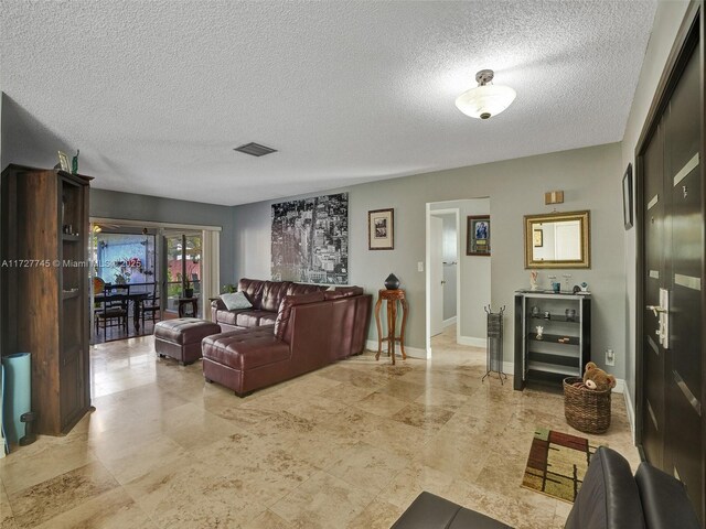 580 Eastwood Ln, Weston, FL 33326 - living room featuring a textured ceiling, beverage cooler, visible vents, and baseboards