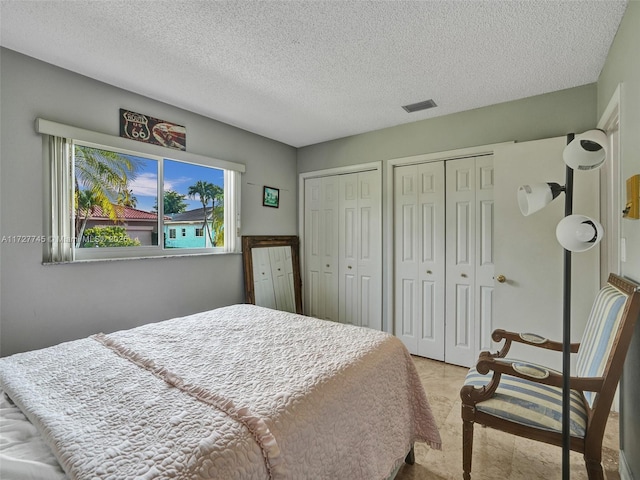 580 Eastwood Ln, Weston, FL 33326 - bedroom featuring a textured ceiling, two closets, and visible vents