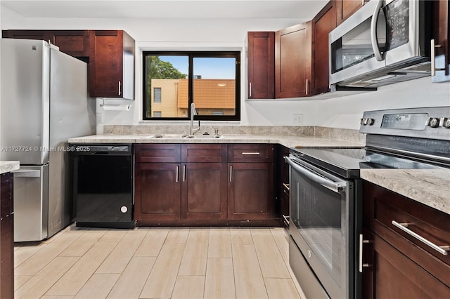 kitchen featuring stainless steel appliances, light hardwood / wood-style floors, and sink