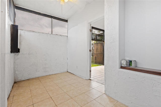 spare room with ceiling fan and light tile patterned flooring