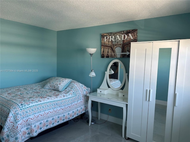 bedroom with a textured ceiling and tile patterned flooring