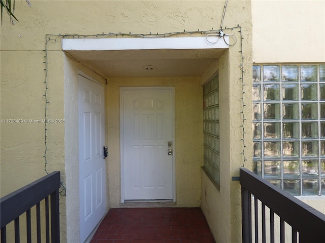 view of exterior entry with a balcony