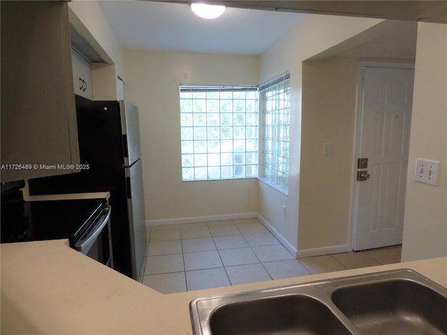 kitchen with sink, light tile patterned floors, and stainless steel electric range