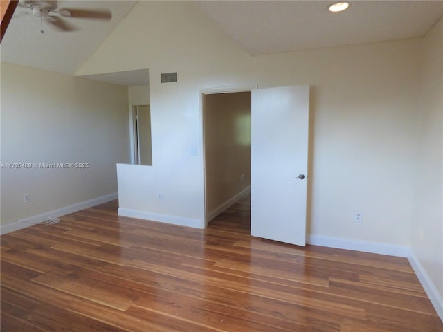 empty room with lofted ceiling, ceiling fan, and dark hardwood / wood-style floors