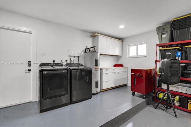 clothes washing area with cabinets, electric water heater, and independent washer and dryer