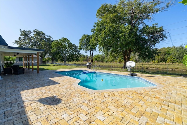 view of swimming pool featuring ceiling fan and a patio area