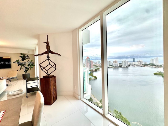 doorway to outside with light tile patterned flooring, a water view, plenty of natural light, and floor to ceiling windows