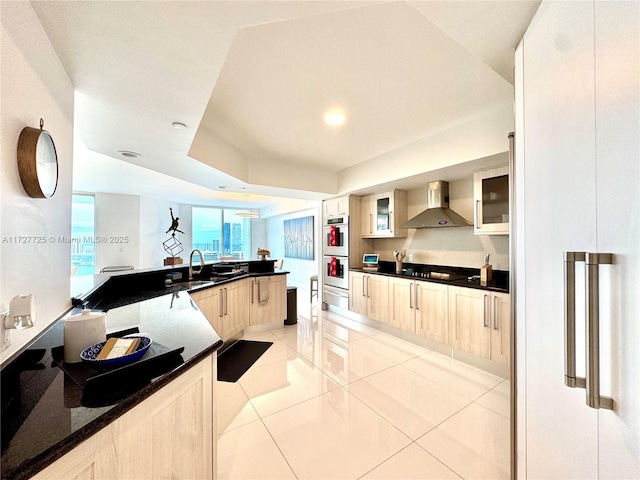 kitchen with light tile patterned flooring, sink, white double oven, black electric stovetop, and wall chimney range hood