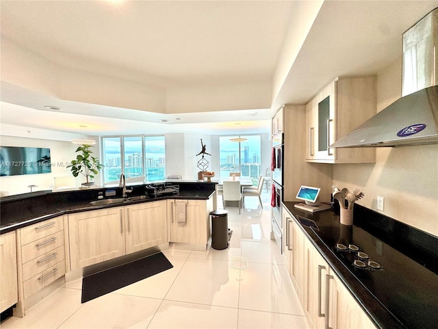 kitchen featuring sink, light tile patterned floors, light brown cabinetry, and wall chimney exhaust hood