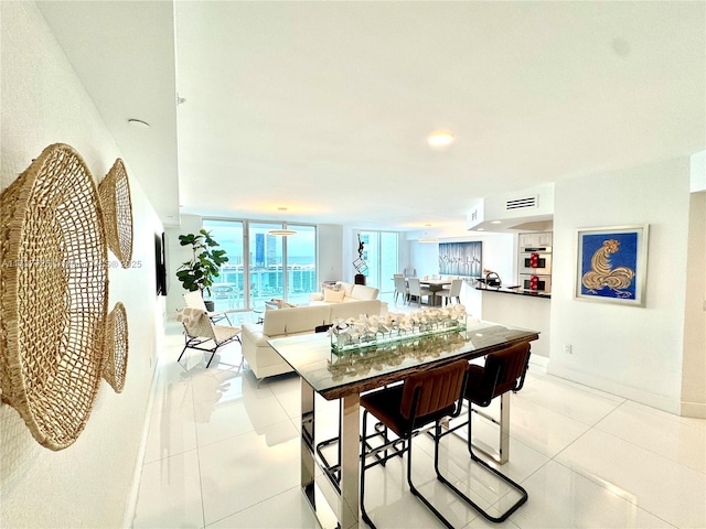 dining room featuring floor to ceiling windows and light tile patterned floors