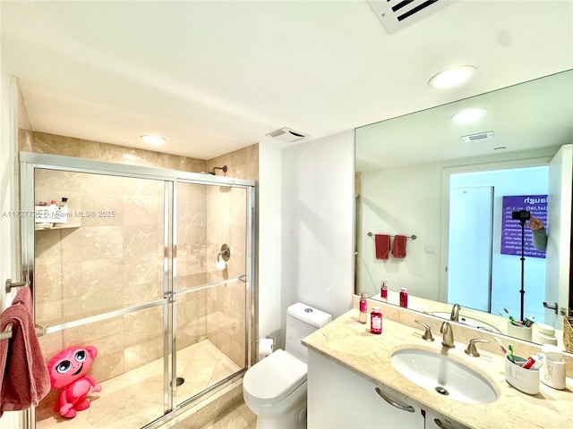 bathroom featuring vanity, a shower with door, and toilet