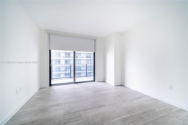 unfurnished room featuring a wall of windows