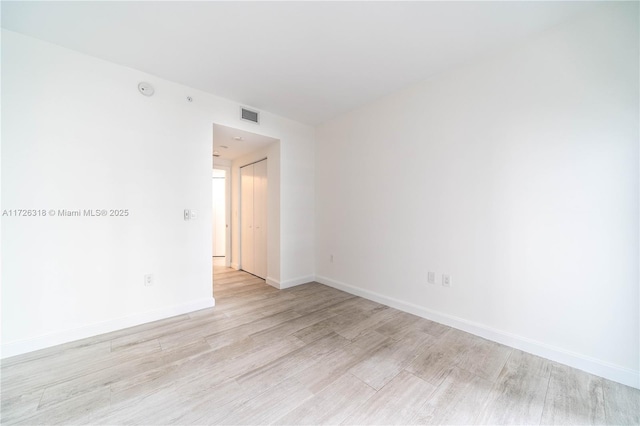 empty room with light hardwood / wood-style flooring