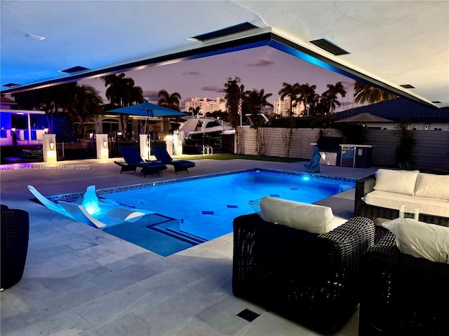 pool at dusk featuring an outdoor hangout area and a patio