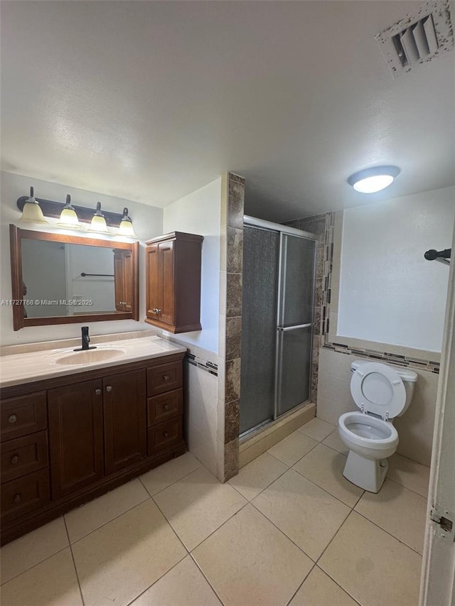 bathroom featuring vanity, tile patterned flooring, and a shower with door