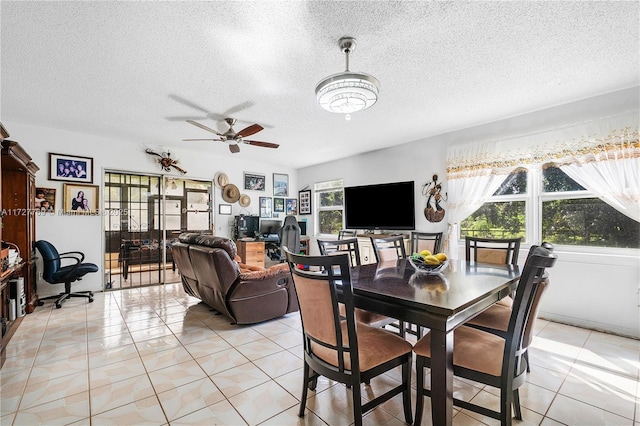 dining area with a textured ceiling, ceiling fan, and light tile patterned flooring