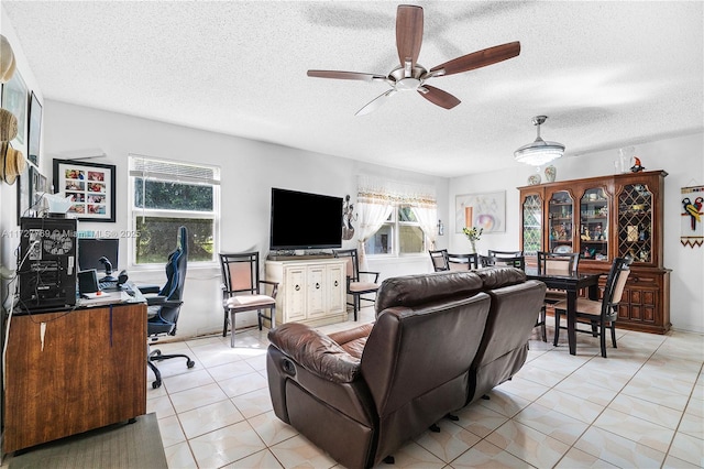 tiled living room featuring a textured ceiling, ceiling fan, and a healthy amount of sunlight