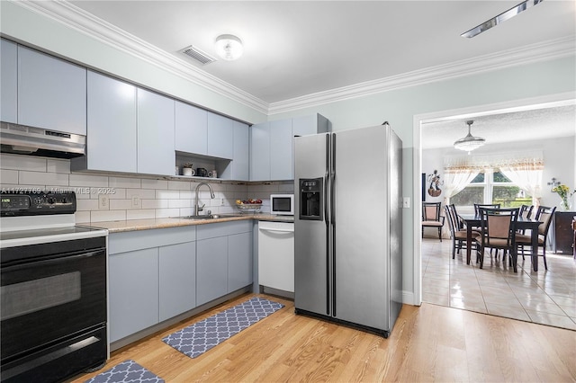 kitchen featuring tasteful backsplash, sink, crown molding, white appliances, and light hardwood / wood-style flooring