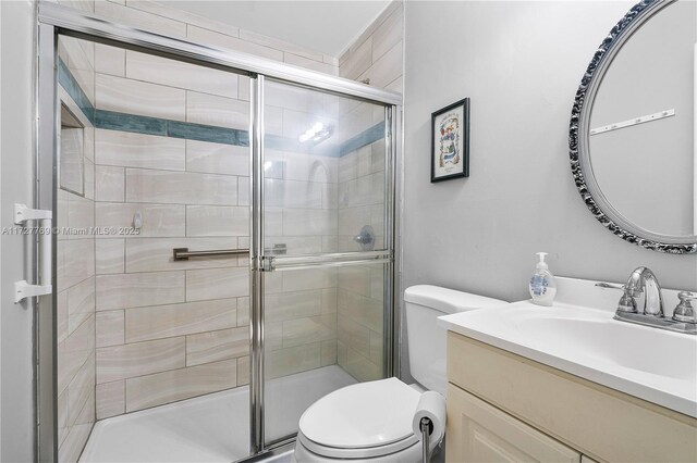 bathroom featuring toilet, vanity, and walk in shower