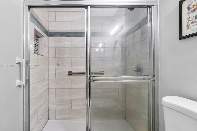 bathroom featuring walk in shower and toilet