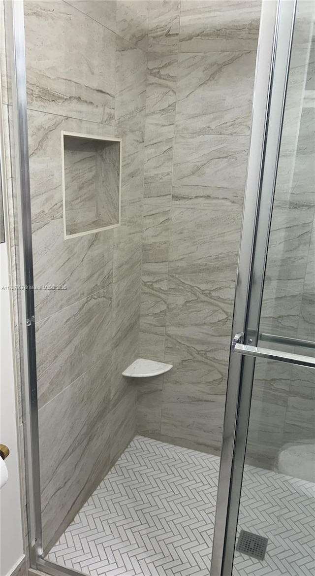 bathroom with a shower with door