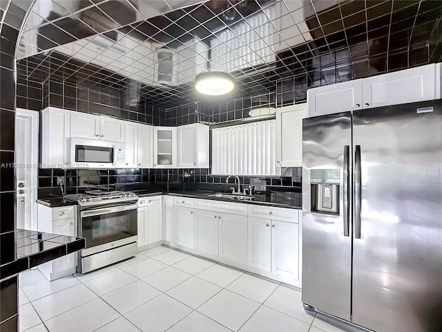 kitchen featuring backsplash, sink, stainless steel appliances, and white cabinetry