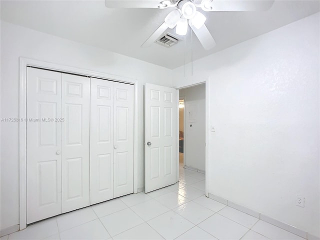 unfurnished bedroom with ceiling fan, light tile patterned floors, and a closet