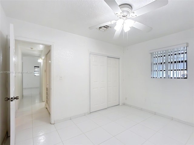 unfurnished bedroom with ceiling fan and a closet