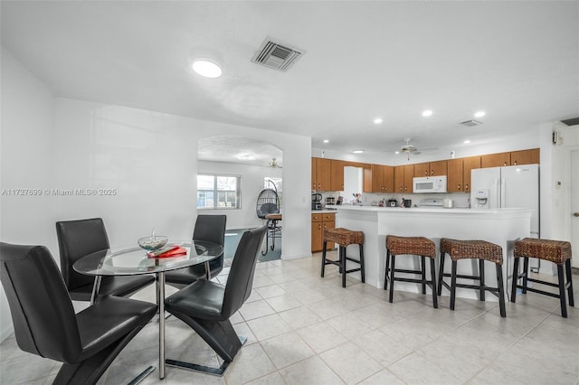 tiled dining area with ceiling fan