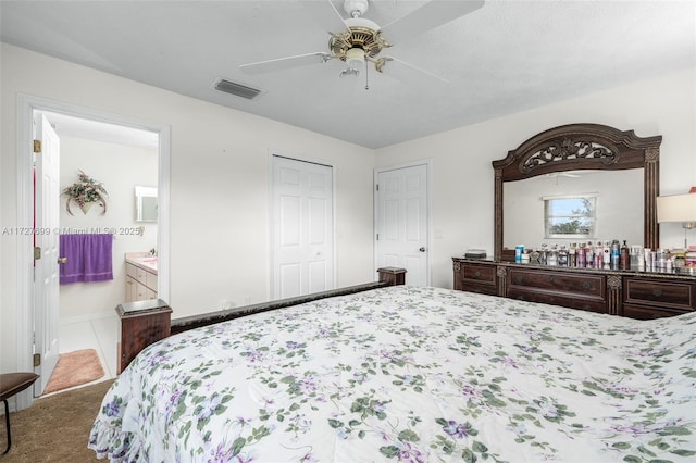 bedroom featuring ceiling fan, ensuite bath, and carpet flooring