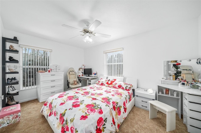 bedroom with ceiling fan and light colored carpet