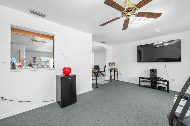 interior space featuring ceiling fan, a textured ceiling, and carpet flooring