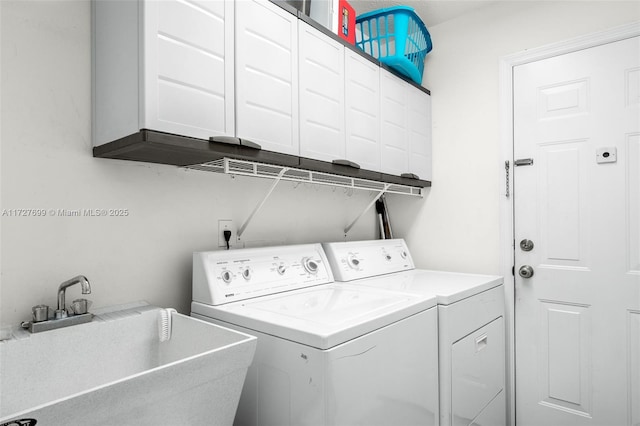 washroom featuring cabinets, sink, and washing machine and clothes dryer