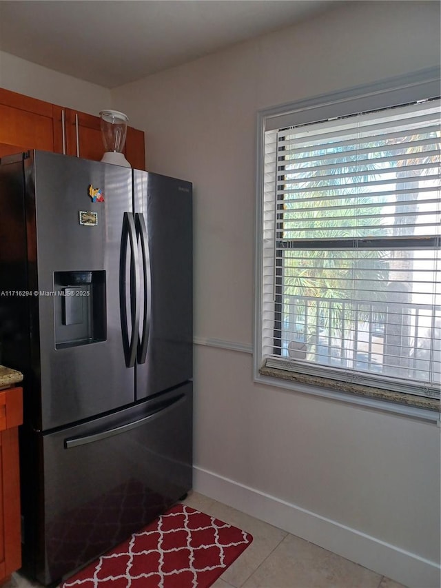 kitchen featuring stainless steel refrigerator with ice dispenser and light tile patterned floors